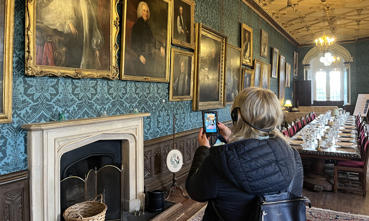 a woman using the new multi media guides at the bishop's palace in wells